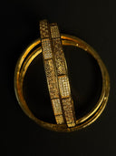 Gold bracelet with intricate design on a black background
