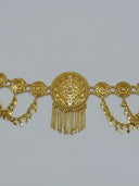 Front view of the waist belt centered on the large filigree medallion with flanking coin disc links, swag charm drops, and chain tassel