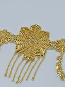 Macro close-up of the large leaf-petal floral centerpiece medallion showing engraved detailing and multi-strand chain tassel with ball tips, flanked by smaller filigree rosette medallions