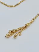 Macro close-up of the multi-strand tassel drop showing stacked graduated faceted beads gathered at a twisted rope knot detail