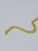 Full flat lay view of the reverse side of the waist belt showing the smooth back of the coin discs and the decorative clasp closure end