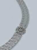 Side angle view of the clover-link mesh chain body showing the wide mesh texture and a single filigree rosette medallion with coin disc drops