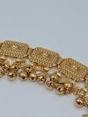 Close-up of three filigree panels showing the open-lattice cutwork, dome sunburst centers, and cascading polished ball and engraved diamond-shaped charm drops