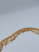 Angled full-length view of the waist belt showing the row of hinged filigree rectangular panels and the full fringe of mixed ball and diamond charm drops