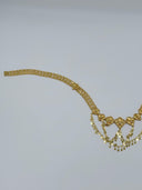 Side angle view of the full belt showing the clover-link mesh chain body, row of heart fan medallions, and cascading coin disc drop fringe from the opposite clasp end