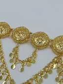 Macro close-up of three filigree medallions showing the open-lattice cutwork, raised floral center motif, rope-twist border, and coin disc drop chain attachments