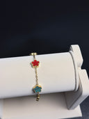 Bracelet with colorful charms on a white stand against a dark background
