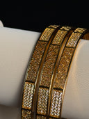 Gold and black patterned belt on a mannequin with a dark background