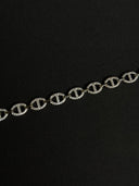 Silver chain with interlocking 'C' logo on a black background
