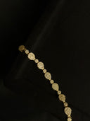 Gold bracelet with diamond-like stones on a black background