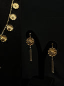 Detail shot of gold-tone flower drop earrings with chain tassel fringe, displayed alongside the long floral charm necklace