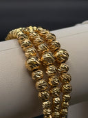 Close-up of bracelet clasp showing lobster-claw closure, adjustable extension chain, and small heart charm in gold-tone