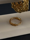 Macro close-up of diamond-cut engraved round beads on gold-tone stacking bracelets showing texture detail