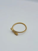 Close-up of gold-tone twisted rope cuff bangle showing textured bullet end caps with chevron engraving