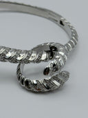 Silver-tone Serpenti-inspired hinged bangle with pavé crystal scale segments and double-coil serpent head terminal, full view