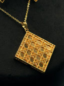Close-up of the Cannage square pendant showing the open-weave cane lattice pattern with beaded border edges and fine rolo-link chain
