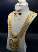 Gold-tone Hilal three-piece jewelry set on a cream bust, featuring a long engraved coin chain necklace with layered crescent moon pendant, matching crescent hook earrings, and crescent ring