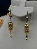 Detail view of the Fanous hook earrings showing the cylindrical filigree lantern with arabesque cutwork body, pointed cone cap, and short chain with gold-tone ball drop