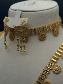 Close-up of the Majd choker showing the rectangular scrollwork clasp with floral motif, three teardrop tassel drops, engraved round medallion drops, and coin-disc chain body