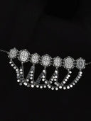 Silver-tone choker with a row of oval filigree medallions and cascading multi-strand chain drops ending in flat polished disc terminals, laid flat on a black background