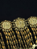 Close-up of three octagonal filigree medallion links on the choker showing the scrollwork border and raised sunburst openwork pattern, with leaf-bead tassel drops below