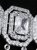 Macro detail of a single choker panel showing the emerald-cut centre stone in a four-prong setting surrounded by a double round pavé halo and stepped octagonal silver-tone border