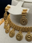 Angled close-up of the choker necklace and opera necklace from the gold-tone medallion coin set, highlighting the beaded detailing and sunburst pendants