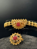 Flat lay of the full Rajwadi bridal set components including layered crescent necklaces, side chain, chandelier earrings, bracelet, ring, and maang tikka in gold tone with pink stone accents