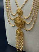 Close-up of the central pendant section showing three stacked open filigree medallions connected vertically with a long cascading bead fringe drop and coin disc finishes at the base