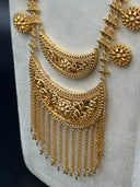 Close-up of the double-layered crescent pendant showing the open filigree floral and scroll detailing on both crescent bodies and the dense multi-strand chain tassel fringe hanging below