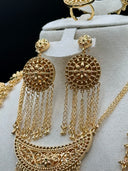 Close-up of the chandelier earrings and upper crescent pendant, showing the round filigree disc earring tops with floral engraving, multi-strand chain tassel drops, and the open filigree scrollwork on the crescent pendant face