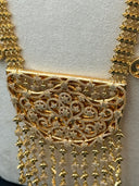 Macro detail of the large half-moon pendant face showing the dense open filigree scrollwork with pave stone-set floral and star clusters throughout, and the cascading chain fringe with star and arrow charm drops below