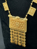 Close-up of the large rectangular pendant showing dense filigree-style engraving with a raised central rosette, flanked by square plaque chain links, with a cascading fringe of floral bead drops and engraved teardrop charm finishes
