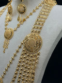 Detail shot of the wide clover-link chain necklace showing the dense multi-strand rows, a large central sunburst medallion with open filigree petal rays, and the cascading chain tassel drops below