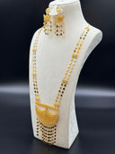 Three-quarter side view of the set on a white bust showing the two parallel diamond-link chains, engraved rectangular filigree connector stations, the crescent mesh pendant, and the matching earrings with clover-and-diamond tassel drops