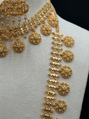 Front view of the matching chandelier earrings on a white bust showing round stone stud tops, large oval open filigree bodies with stone-set floral clusters, and multi-strand clover chain tassel drops with coin disc finishes