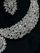 Macro detail of the collar necklace body showing layered marquise, oval, and round-cut clear stones in a cascading floral leaf motif