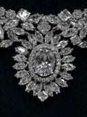 Extreme close-up of the large oval halo centerpiece pendant showing the central oval stone, pavé halo border, and radiating marquise stone surround