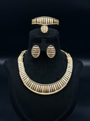 Full 4-piece tri-tone ribbed jewelry set displayed on a black velvet bust — collar necklace, cuff bracelet, oval stud earrings, and domed ring