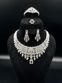 Full view of the 4-piece silver-tone lavender zirconia set on a black bust, showing the bib necklace, chandelier earrings, cuff bangle, and cocktail ring