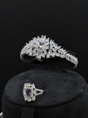 Close-up of the marquise leaf cuff bangle with rectangular halo centerpiece and the matching rectangular halo cocktail ring displayed on a black stand