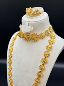 Angled side view of the filigree flower set showing the choker necklace, drop earrings, and opera-length necklace draped across a white velvet bust