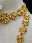 Close-up of the filigree flower links on the choker and long necklace showing open petal detailing, beaded border edges, and faceted bead spacers
