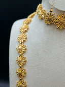 Detail shot of the opera necklace shoulder section and drop earring showing individual filigree flower motif with beaded border and hook back