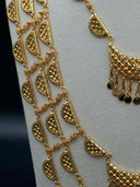 Front center view of the long half-moon link necklace showing the graduated crescent pendant drop with coin fringe at the center