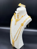 Close-up of the long necklace center showing three graduated filigree daisy stations with multi-strand clover drop tassels and the matching drop earrings