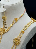 Close-up of the cuff bracelet showing the large open-petal filigree daisy centerpiece with engraved leaf texture on a double clover link band
