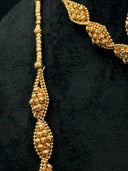 Detail shot of a single large diamond station on the opera necklace showing the twisted bead cluster construction, pinched ends, and swelled center alongside the collar necklace