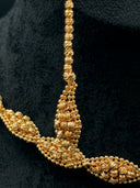 Close-up of the collar necklace center showing the tapered bead cluster drop earring alongside the diamond station necklace, highlighting the faceted bead texture and twisted strand detail