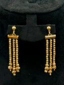 Close-up of the 3-strand tassel drop earrings on a black velvet stand showing ball stud top, cylindrical bar connector, three parallel bead strand drops, and twisted ball base